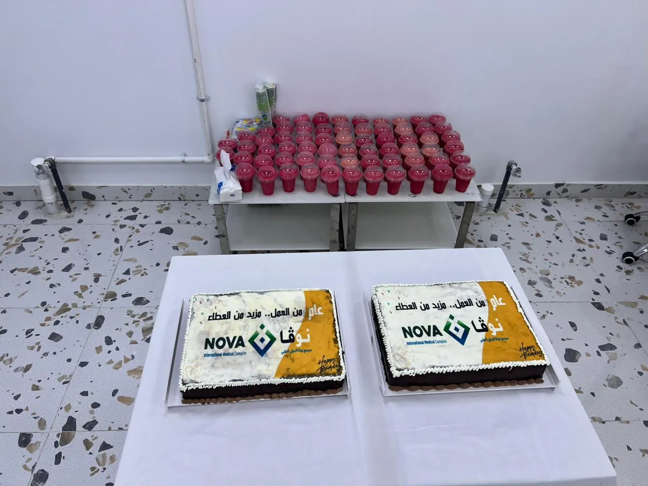 كعكتا الاحتفال بشعار نوفا وعبارة «عام من العمل.. مزيد من العطاء» مع الضيافة