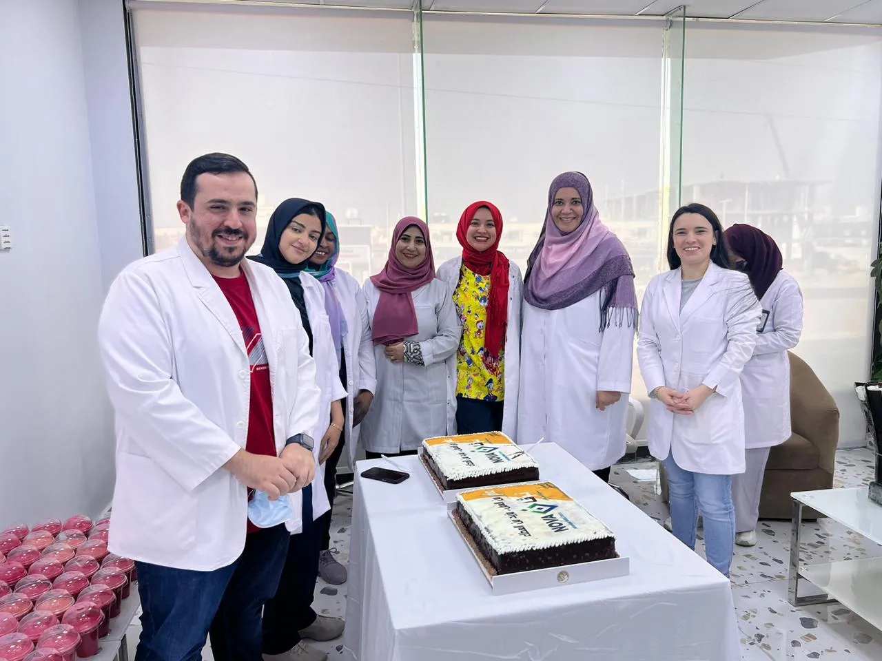 أعضاء الفريق الطبي مصطفّون حول طاولة الكعك في الحفل