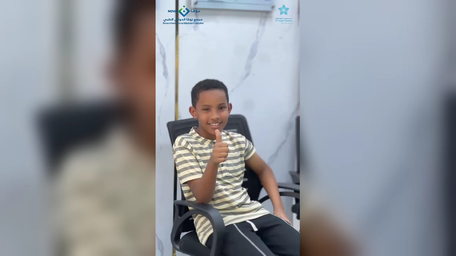 طفل يجلس على كرسي العيادة ويرفع إبهامه بعد أخذ تطعيم الإنفلونزا الموسمية في مجمع نوفا الدولي الطبي